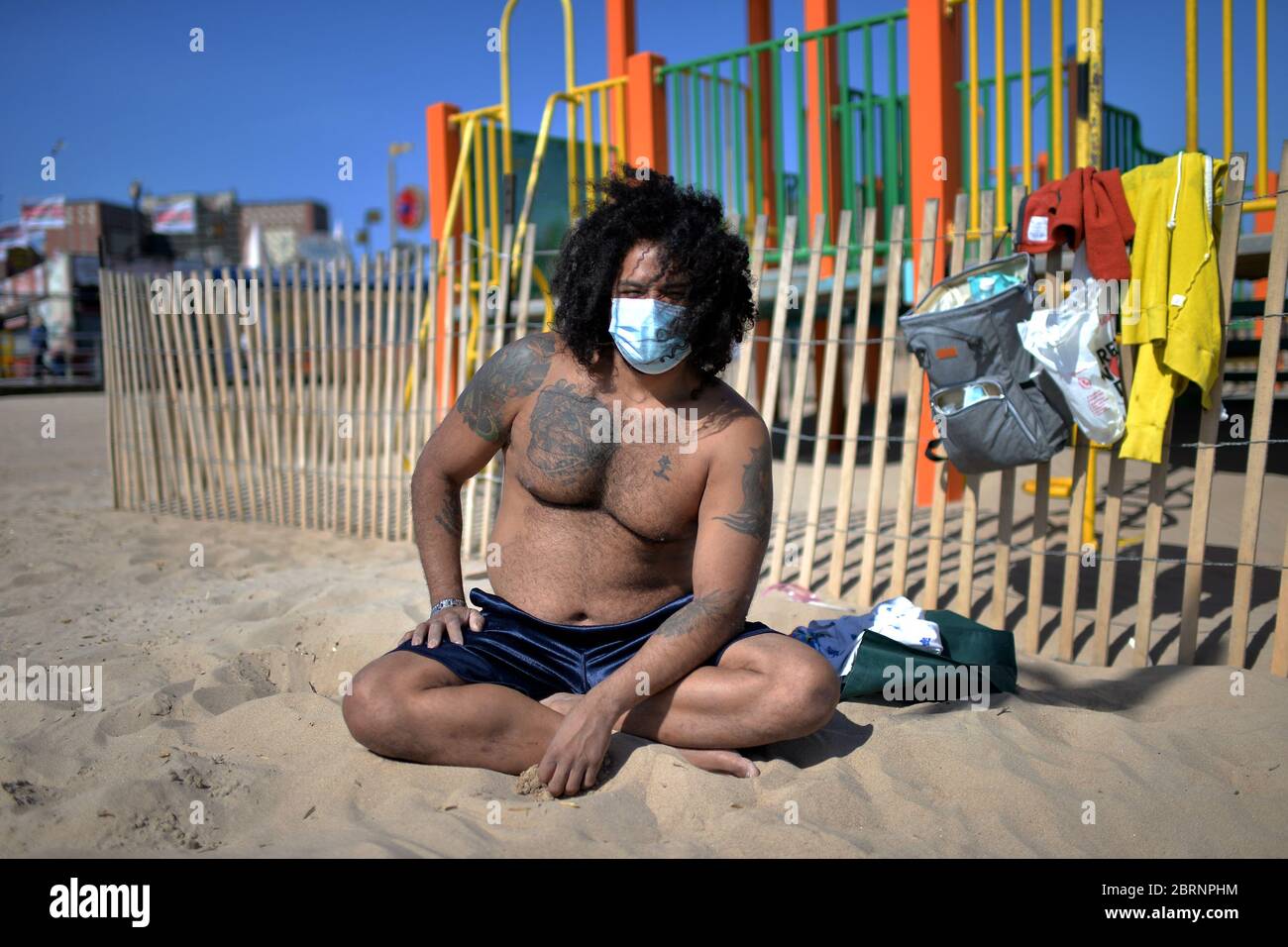 New York City, USA. Mai 2020. Jose Flores trägt eine Gesichtsmaske zur Zeit der COVID-19-Pandemie und posiert für ein Bild am Coney Island Beach im Brooklyn-Bezirk von New York City, NY, 21. Mai 2020. Die NYPD kündigte an, dass sie am Memorial Day Wochenende die Strände patrouillieren wird, um die soziale Distanz zu genießen und Masken auszuteilen, und sagte, Strandbesucher können nur knöcheltief ins Wasser gehen, kein Schwimmen ist erlaubt, aber Surfen wird erlaubt sein. (Anthony Behar/Sipa USA) Credit: SIPA USA/Alamy Live News Stockfoto