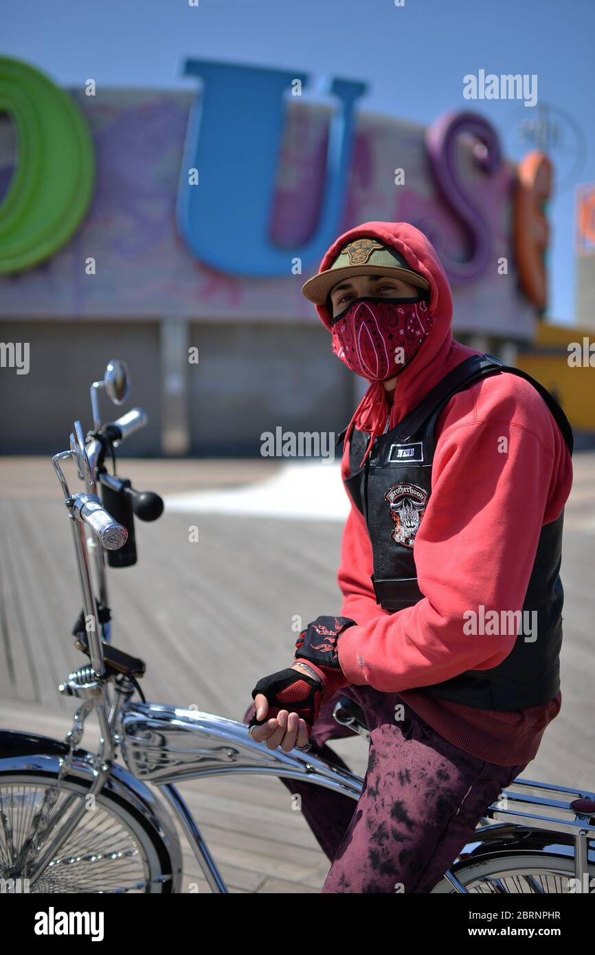 New York City, USA. Mai 2020. Rene Otero trägt eine Maske in der Zeit der COVID-19 Pandemie, als er sein maßgeschneidertes Fahrrad entlang der Coney Island Promenade im Brooklyn-Bezirk von New York City, NY, am 21. Mai 2020, fährt. Die NYPD kündigte an, dass sie am Memorial Day Wochenende die Strände patrouillieren wird, um die soziale Distanz zu genießen und Masken auszuteilen, und sagte, Strandbesucher können nur knöcheltief ins Wasser gehen, kein Schwimmen ist erlaubt, aber Surfen wird erlaubt sein. (Anthony Behar/Sipa USA) Credit: SIPA USA/Alamy Live News Stockfoto