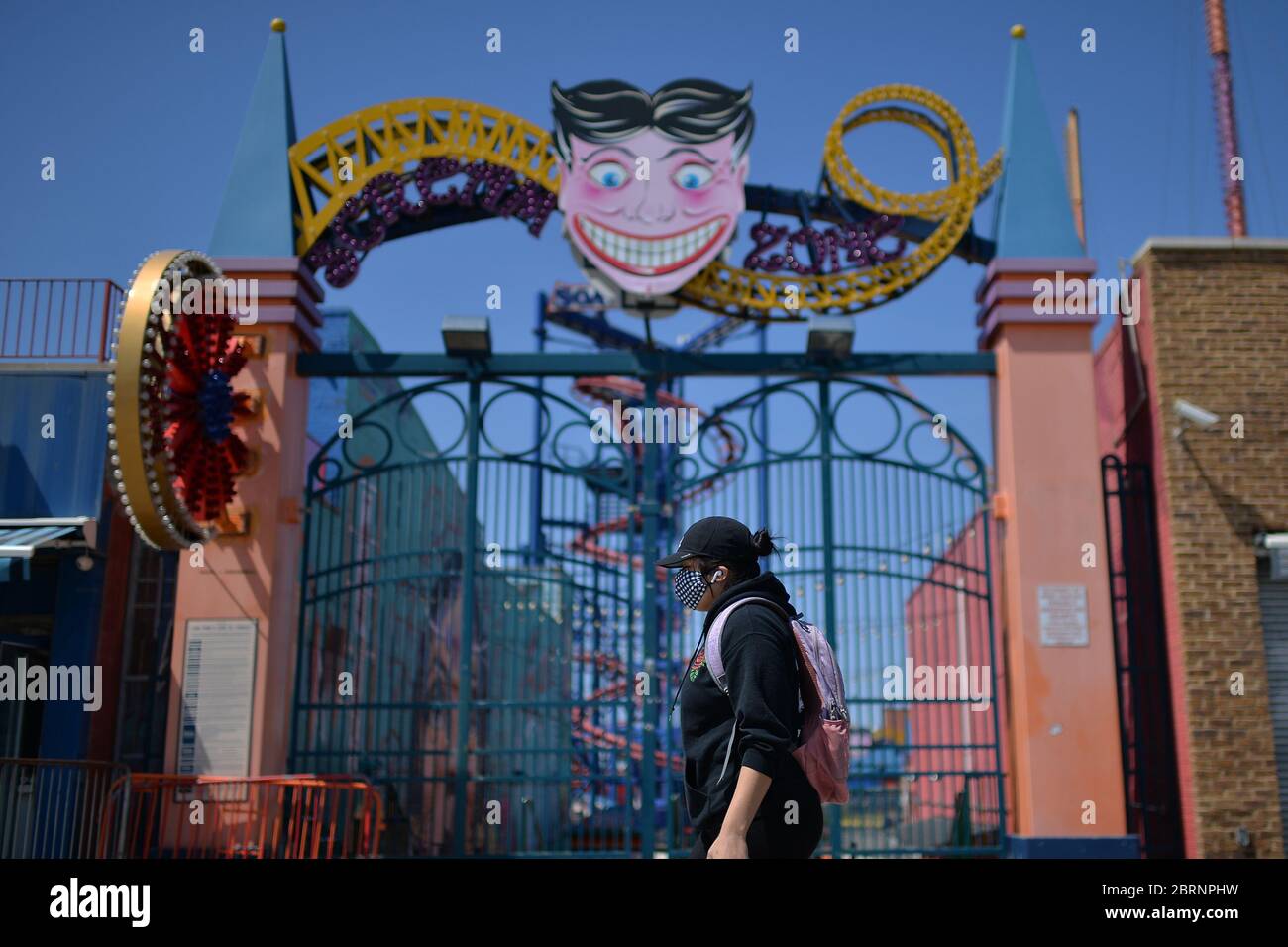 New York City, USA. Mai 2020. Eine Frau, die zur Zeit der COVID-19-Pandemie eine Maske trug, läuft unter einem Vergnügungspark entlang der Strandpromenade von Coney Island im Brooklyn-Bezirk New York City, NY, 21. Mai 2020. Die NYPD kündigte an, dass sie am Memorial Day Wochenende die Strände patrouillieren wird, um die soziale Distanz zu genießen und Masken auszuteilen, und sagte, Strandbesucher können nur knöcheltief ins Wasser gehen, kein Schwimmen ist erlaubt, aber Surfen wird erlaubt sein. (Anthony Behar/Sipa USA) Credit: SIPA USA/Alamy Live News Stockfoto