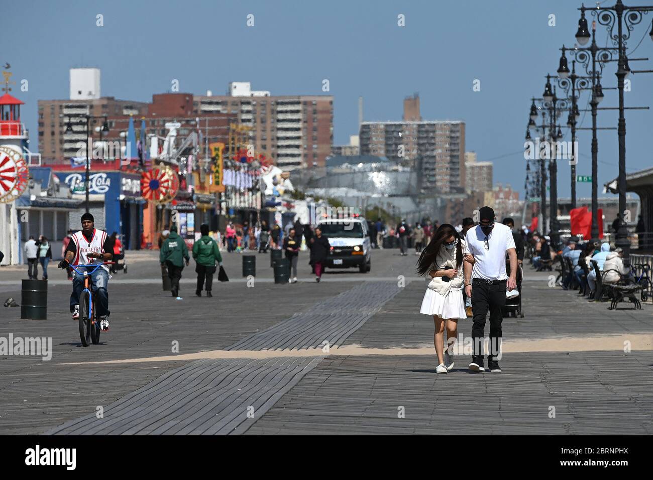 New York City, USA. Mai 2020. Einige tragen Gesichtsmasken und andere nicht in der Zeit der COVID-19 Pandemie, Menschen gehen entlang der Coney Island Promenade in Brooklyn Bezirk von New York City, NY, 21. Mai 2020. Die NYPD kündigte an, dass sie am Memorial Day Wochenende die Strände patrouillieren wird, um die soziale Distanz zu genießen und Masken auszuteilen, und sagte, Strandbesucher können nur knöcheltief ins Wasser gehen, kein Schwimmen ist erlaubt, aber Surfen wird erlaubt sein. (Anthony Behar/Sipa USA) Credit: SIPA USA/Alamy Live News Stockfoto
