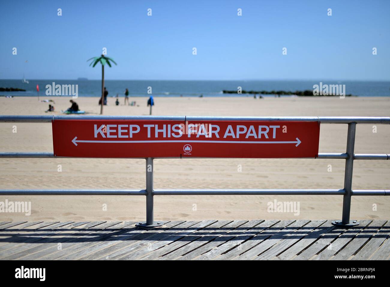 New York City, USA. Mai 2020. Zur Zeit der COVID-19-Pandemie hängt ein Schild, das über eine Höhe von etwa 1,2 m misst, am Geländer am Strand von Coney Island im Stadtteil Brooklyn von New York City, NY, 21. Mai 2020. Die NYPD kündigte an, dass sie am Memorial Day Wochenende die Strände patrouillieren wird, um die soziale Distanz zu genießen und Masken auszuteilen, und sagte, Strandbesucher können nur knöcheltief ins Wasser gehen, kein Schwimmen ist erlaubt, aber Surfen wird erlaubt sein. (Anthony Behar/Sipa USA) Credit: SIPA USA/Alamy Live News Stockfoto