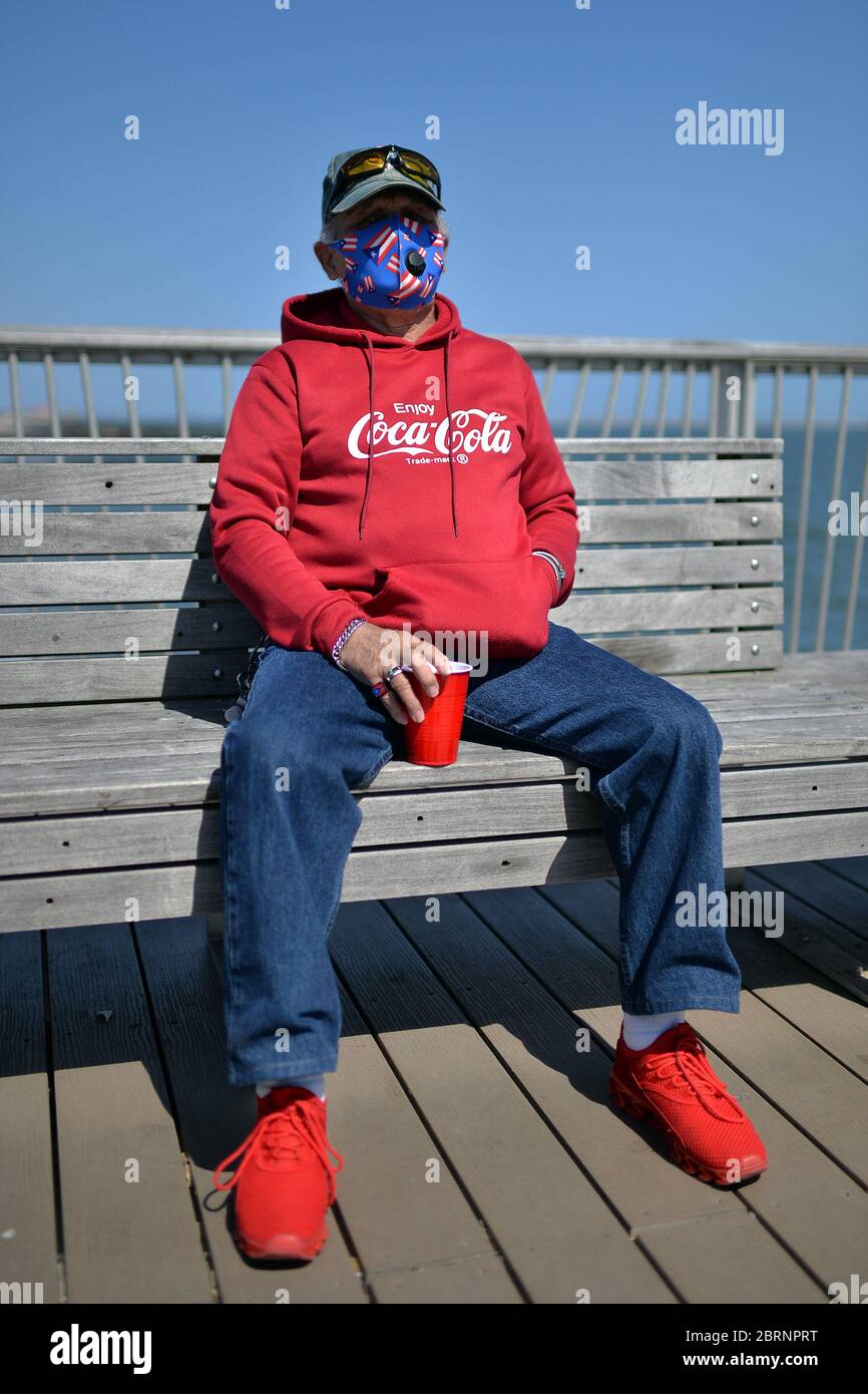 New York City, USA. Mai 2020. Maximo Vega, der zur Zeit der COVID-19-Pandemie eine mit Puerto Ricaner Flagge geschmückte Gesichtsmaske trug, feiert seinen 77. Geburtstag am Pier von Coney Island im Brooklyn-Bezirk New York City, NY, 21. Mai 2020. Die NYPD kündigte an, dass sie am Memorial Day Wochenende die Strände patrouillieren wird, um die soziale Distanz zu genießen und Masken auszuteilen, und sagte, Strandbesucher können nur knöcheltief ins Wasser gehen, kein Schwimmen ist erlaubt, aber Surfen wird erlaubt sein. (Anthony Behar/Sipa USA) Credit: SIPA USA/Alamy Live News Stockfoto