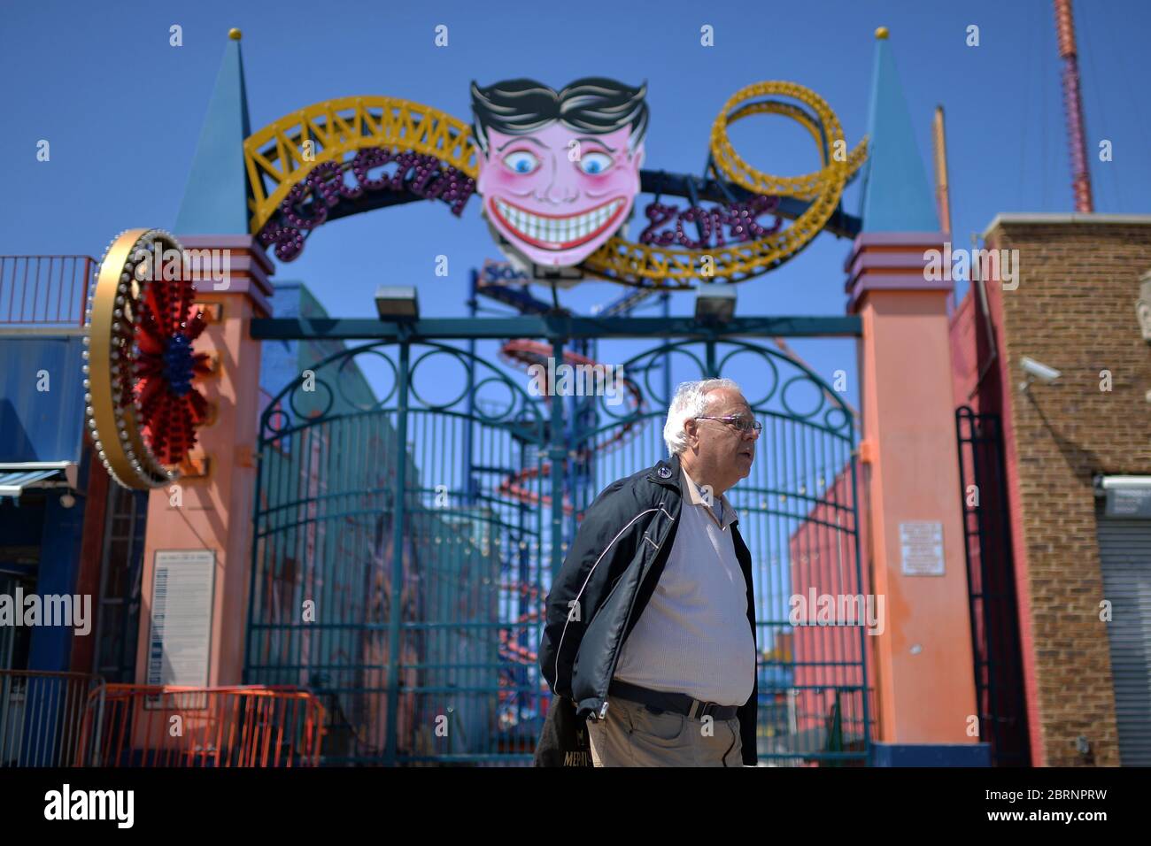 New York City, USA. Mai 2020. Ein Mann, der zur Zeit der COVID-19-Pandemie keine Maske trug, läuft unter einem Vergnügungspark-Schild entlang der Promenade von Coney Island im Brooklyn-Bezirk New York City, NY, 21. Mai 2020. Die NYPD kündigte an, dass sie am Memorial Day Wochenende die Strände patrouillieren wird, um die soziale Distanz zu genießen und Masken auszuteilen, und sagte, Strandbesucher können nur knöcheltief ins Wasser gehen, kein Schwimmen ist erlaubt, aber Surfen wird erlaubt sein. (Anthony Behar/Sipa USA) Credit: SIPA USA/Alamy Live News Stockfoto