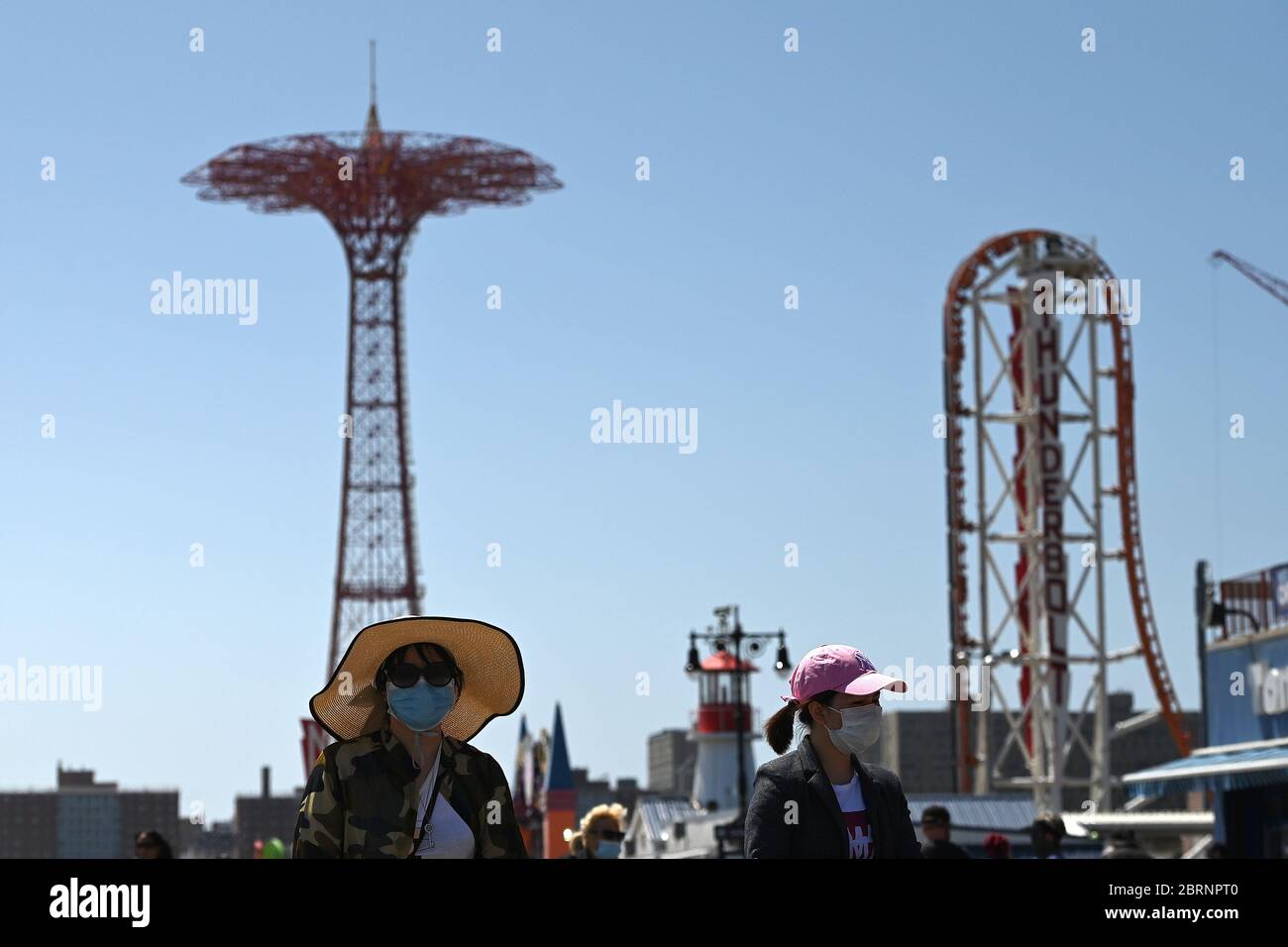 New York City, USA. Mai 2020. Während der COVID-19-Pandemie tragen die Menschen Gesichtsmasken und spazieren entlang der Strandpromenade von Coney Island im Brooklyn-Bezirk von New York City, NY, 21. Mai 2020. Die NYPD kündigte an, dass sie am Memorial Day Wochenende die Strände patrouillieren wird, um die soziale Distanz zu genießen und Masken auszuteilen, und sagte, Strandbesucher können nur knöcheltief ins Wasser gehen, kein Schwimmen ist erlaubt, aber Surfen wird erlaubt sein. (Anthony Behar/Sipa USA) Credit: SIPA USA/Alamy Live News Stockfoto