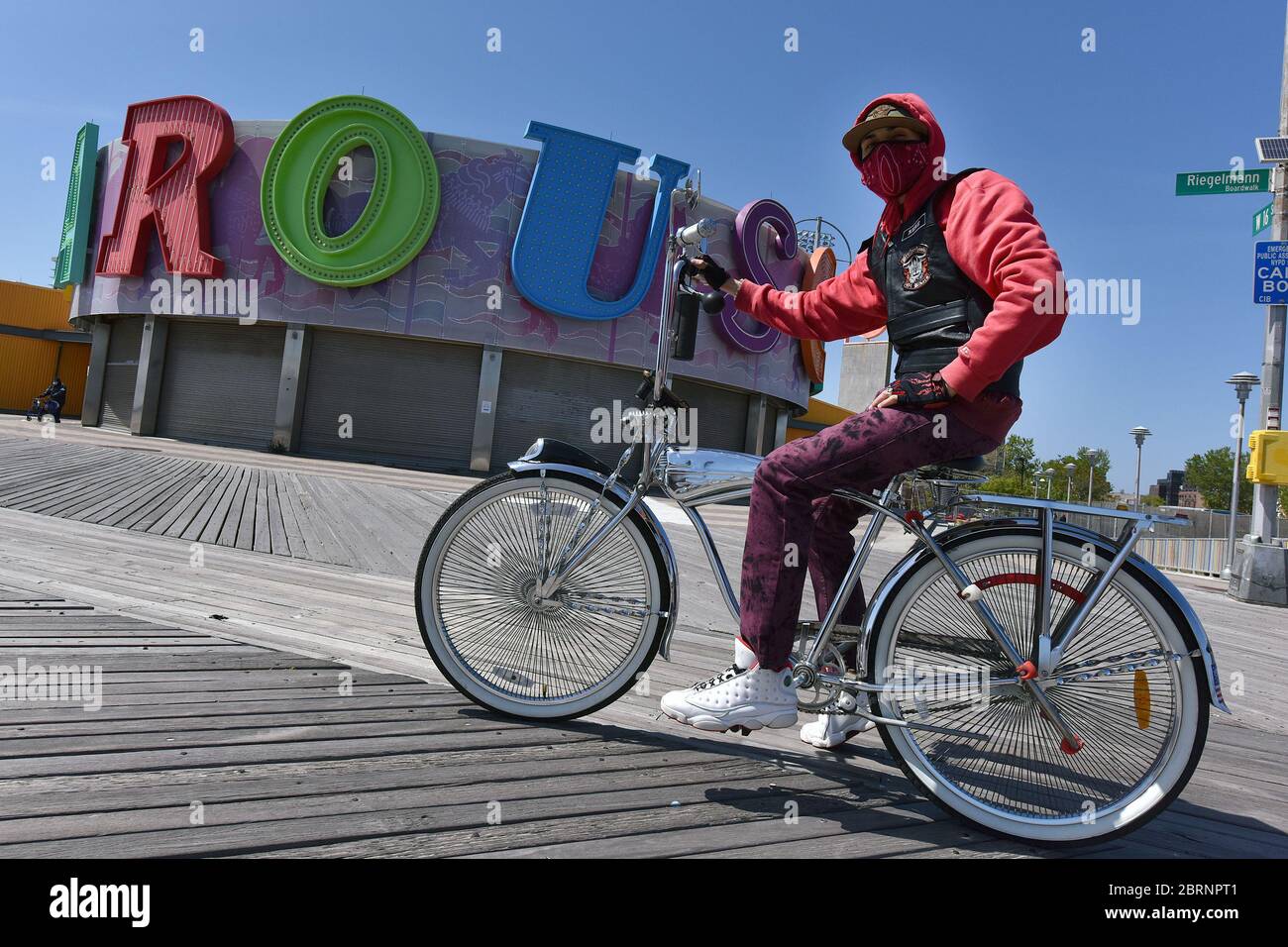 New York City, USA. Mai 2020. Rene Otero trägt eine Maske in der Zeit der COVID-19 Pandemie, als er sein maßgeschneidertes Fahrrad entlang der Coney Island Promenade im Brooklyn-Bezirk von New York City, NY, am 21. Mai 2020, fährt. Die NYPD kündigte an, dass sie am Memorial Day Wochenende die Strände patrouillieren wird, um die soziale Distanz zu genießen und Masken auszuteilen, und sagte, Strandbesucher können nur knöcheltief ins Wasser gehen, kein Schwimmen ist erlaubt, aber Surfen wird erlaubt sein. (Anthony Behar/Sipa USA) Credit: SIPA USA/Alamy Live News Stockfoto
