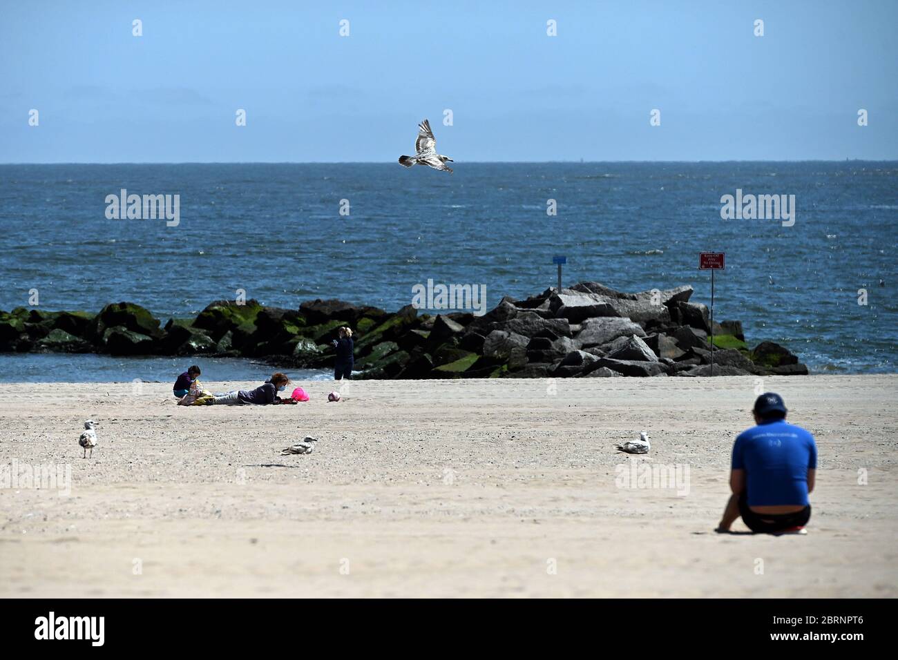 New York City, USA. Mai 2020. Strandgänger üben soziale Distanz am Coney Island Strand im Brooklyn Bezirk von New York City, NY, 21. Mai 2020. Die NYPD kündigte an, dass sie am Memorial Day Wochenende die Strände patrouillieren wird, um die soziale Distanz zu genießen und Masken auszuteilen, und sagte, Strandbesucher können nur knöcheltief ins Wasser gehen, kein Schwimmen ist erlaubt, aber Surfen wird erlaubt sein. (Anthony Behar/Sipa USA) Credit: SIPA USA/Alamy Live News Stockfoto