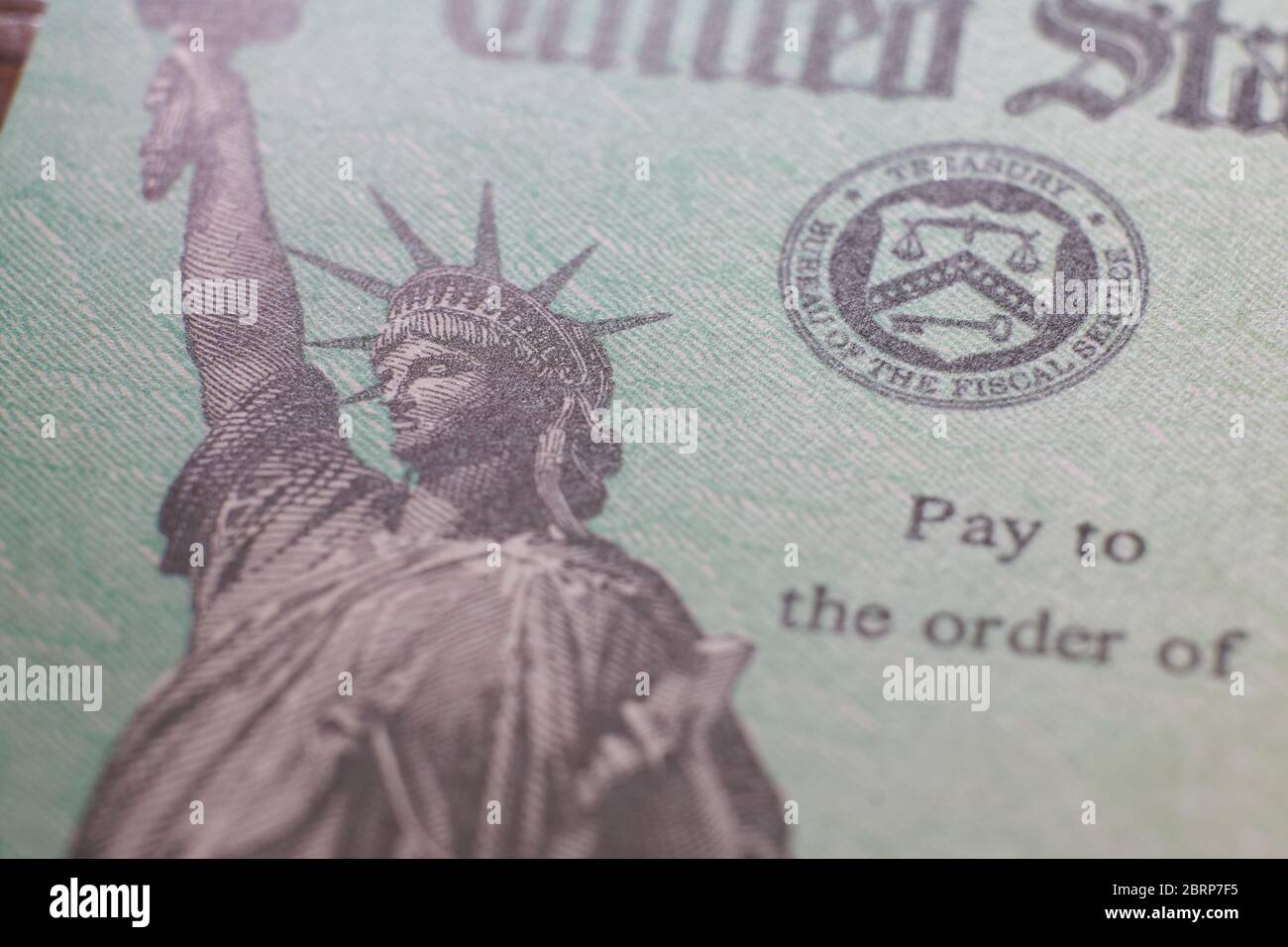 Text und Freiheitsstatue-Logo auf dem Scheck (Scheck) der US-Finanzministerium über die Zahlung der wirtschaftlichen Auswirkungen (Entlastung durch COVID-19-Pandemie). Stockfoto