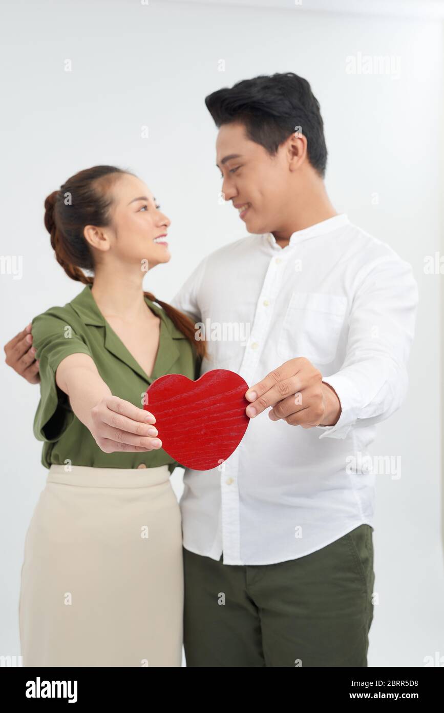 Junge Liebe Paar mit rotem Herz, glücklich Lächeln Umarmung, isoliert auf weißem Hintergrund, valentinstag Konzept Stockfoto