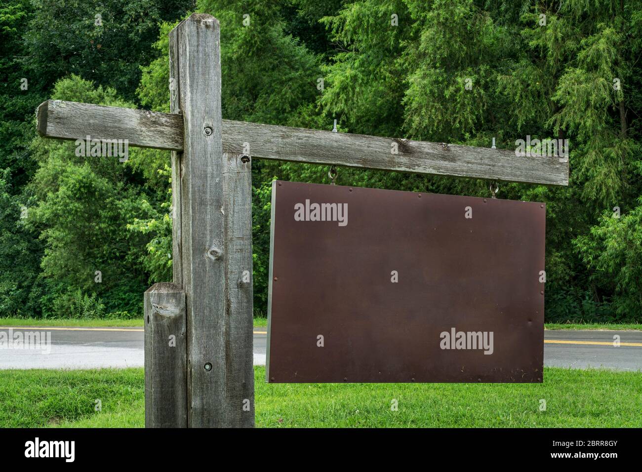 Leeres Parkeingang oder Wegweiser gegen grüne Bäume Stockfoto