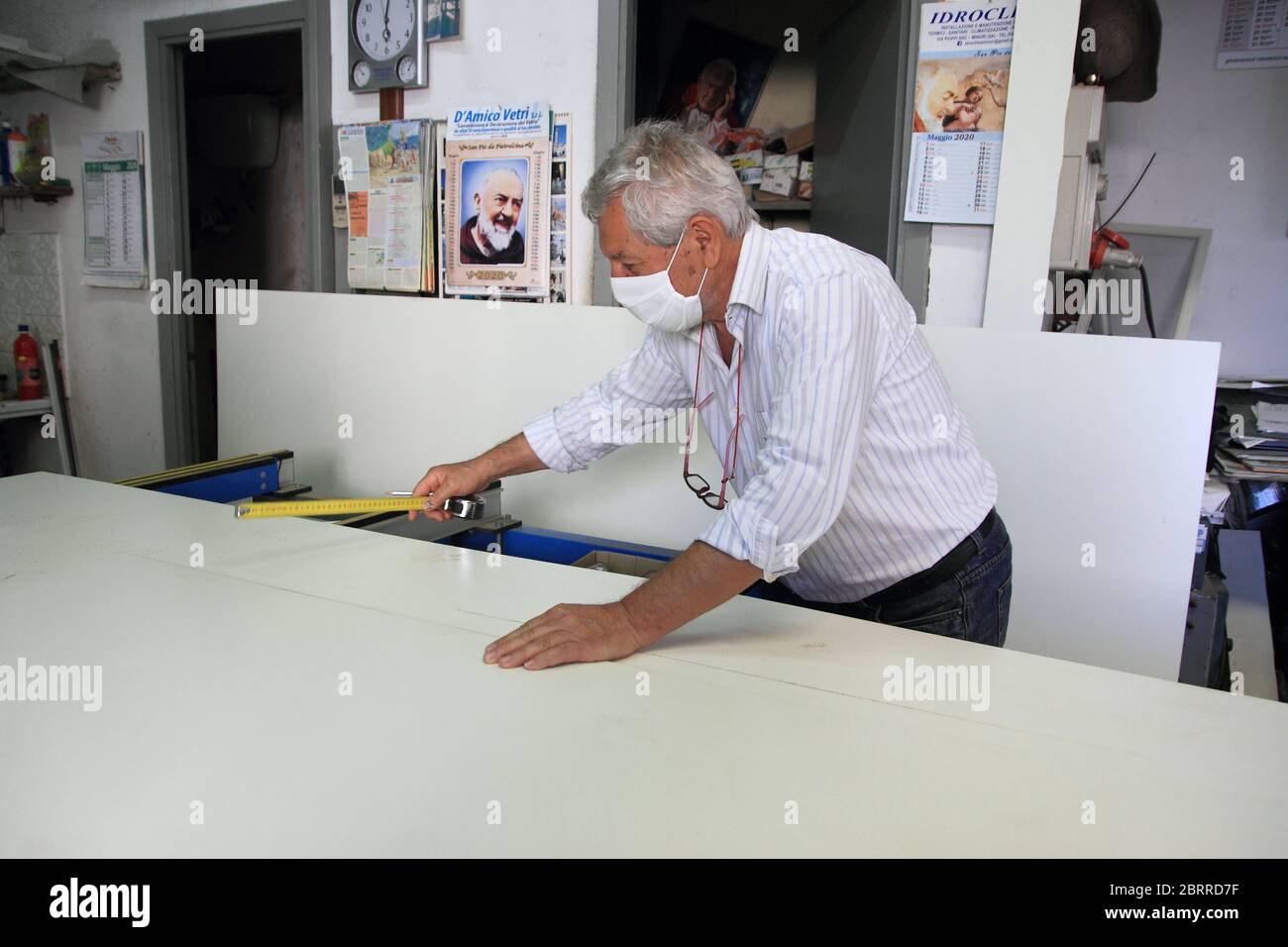 Ein Handwerker von Aluminium-Armaturen in seiner Werkstatt während der Arbeit der Vorbereitung einer Tür. Maske für die Anti-Fälschungsvorschriften Stockfoto