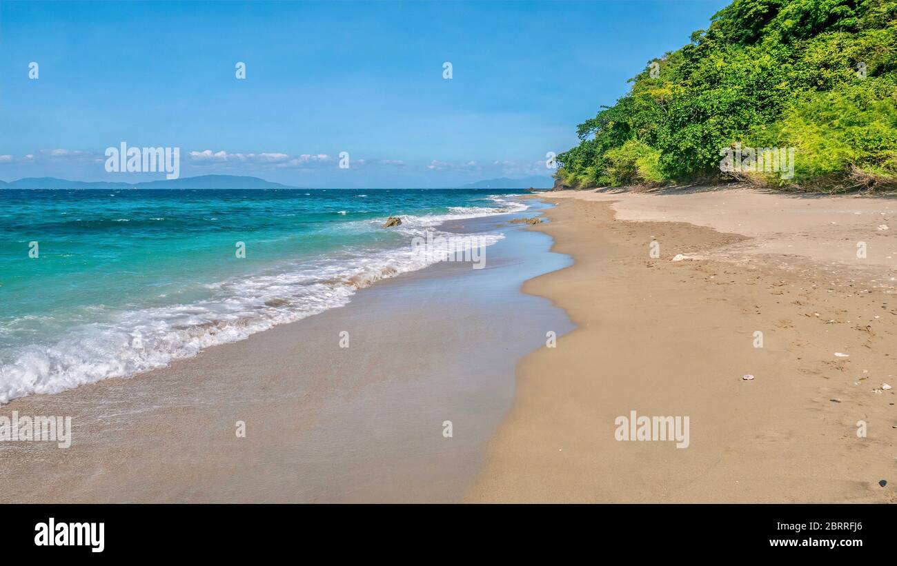 Ein wunderschöner, einsamer Strand, da eine Ebbe nassen Sand auf der Nordseite der Insel Mindoro in der Nähe von Abra de ILOG, Philippinen, hinterlässt. Stockfoto