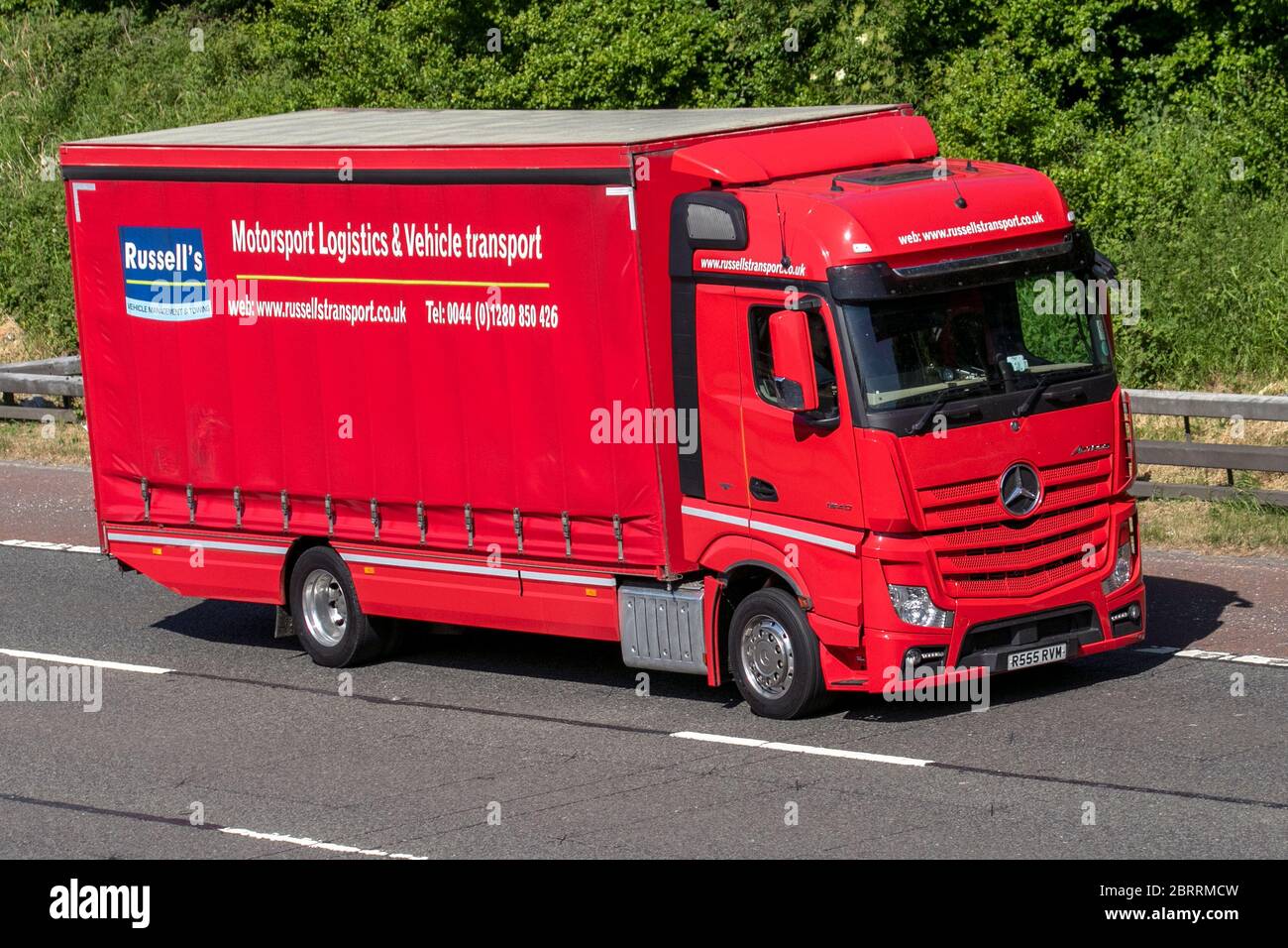 Russells Transport - Motorsport Logistik und Rennen Auto Transport & Vehicle Transport; Spedition Lieferwagen, Red LKW, Transport, LKW, Frachtführer, Mercedes Benz Fahrzeug, europäischen gewerblichen Transport, Industrie, M6 in Manchester, Großbritannien Stockfoto