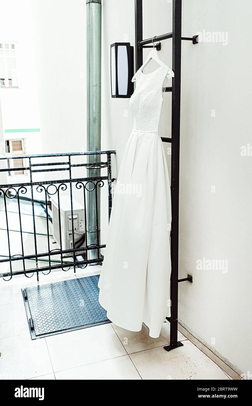 Wunderschöne weiße Hochzeitskleid auf einer Feuerleiter auf dem Balkon. Braut Accessoires in einem Hochzeitstag Stockfoto