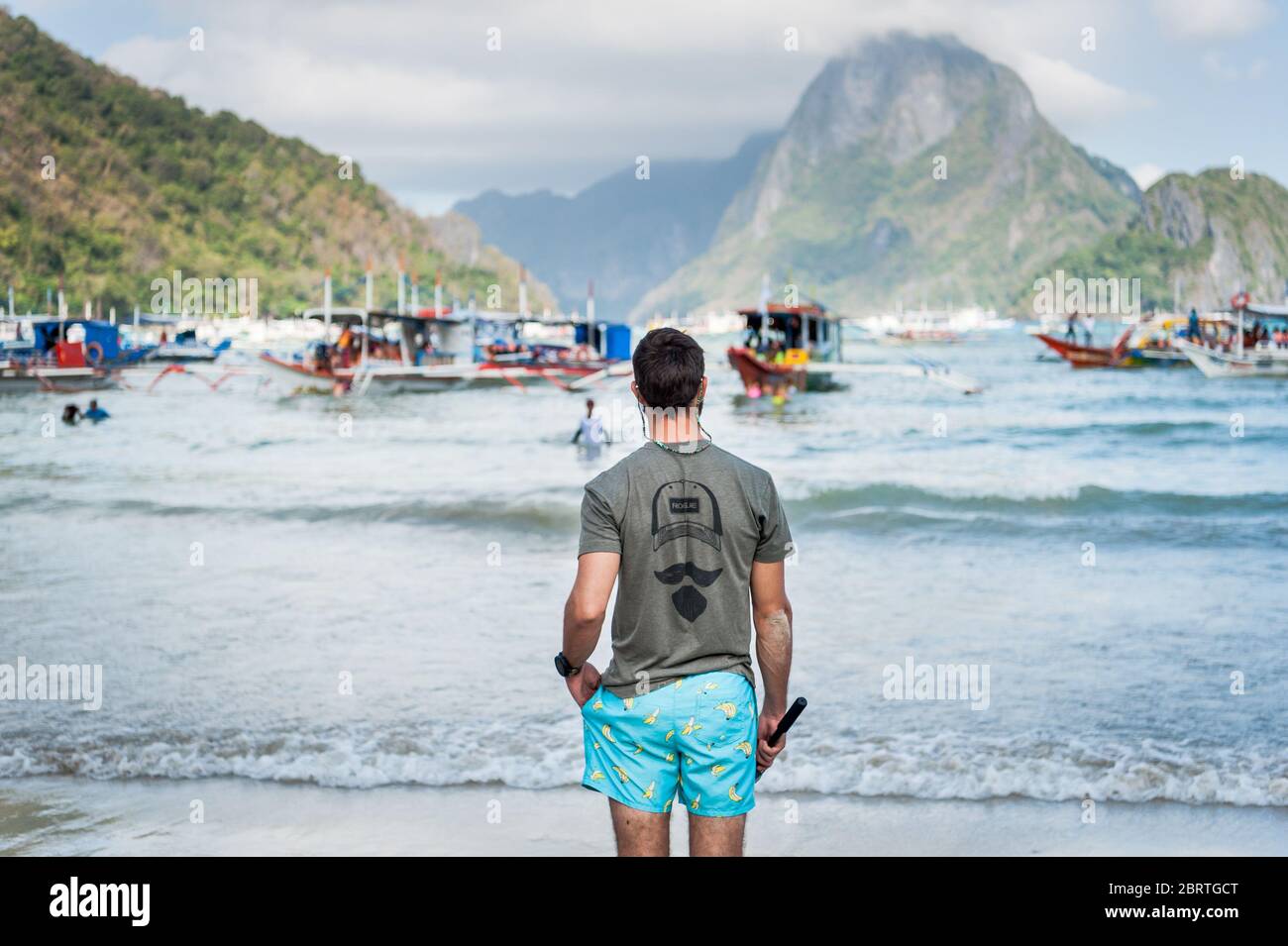 Morgenszene am Hauptstrand von El Nido, Philippinen, während Touristen auf Tagesbooten fahren. Stockfoto