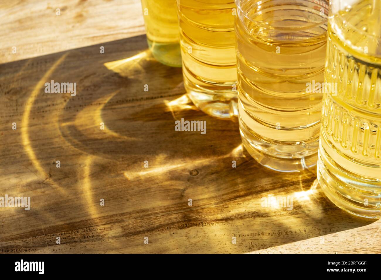 Gelbe Lichtreflexe aus Sonnenstrahl- und Ölflaschen Stockfoto