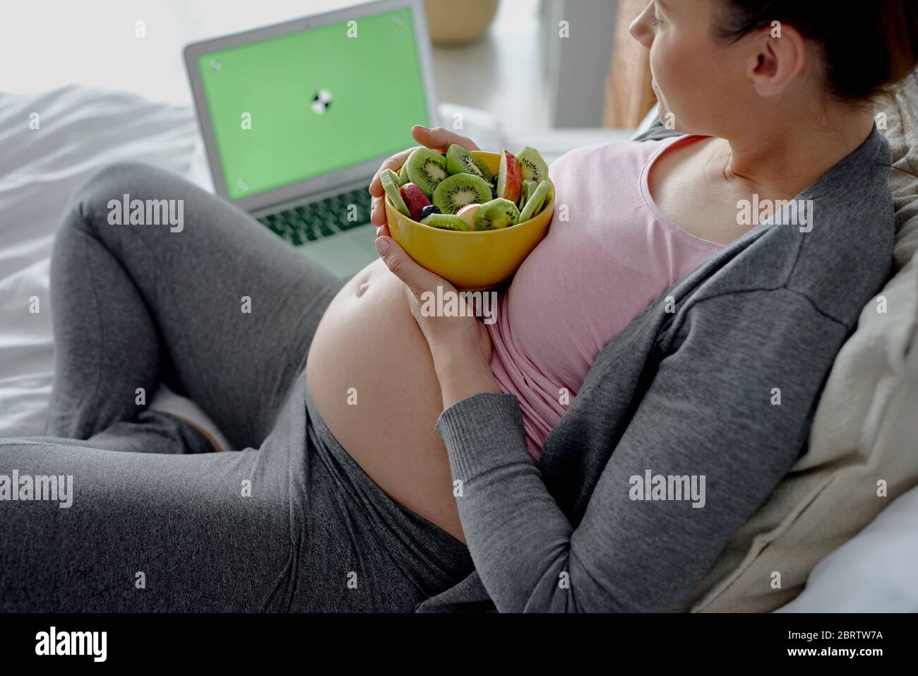 Schwangere Frau entspannt vor dem Computer Stockfoto