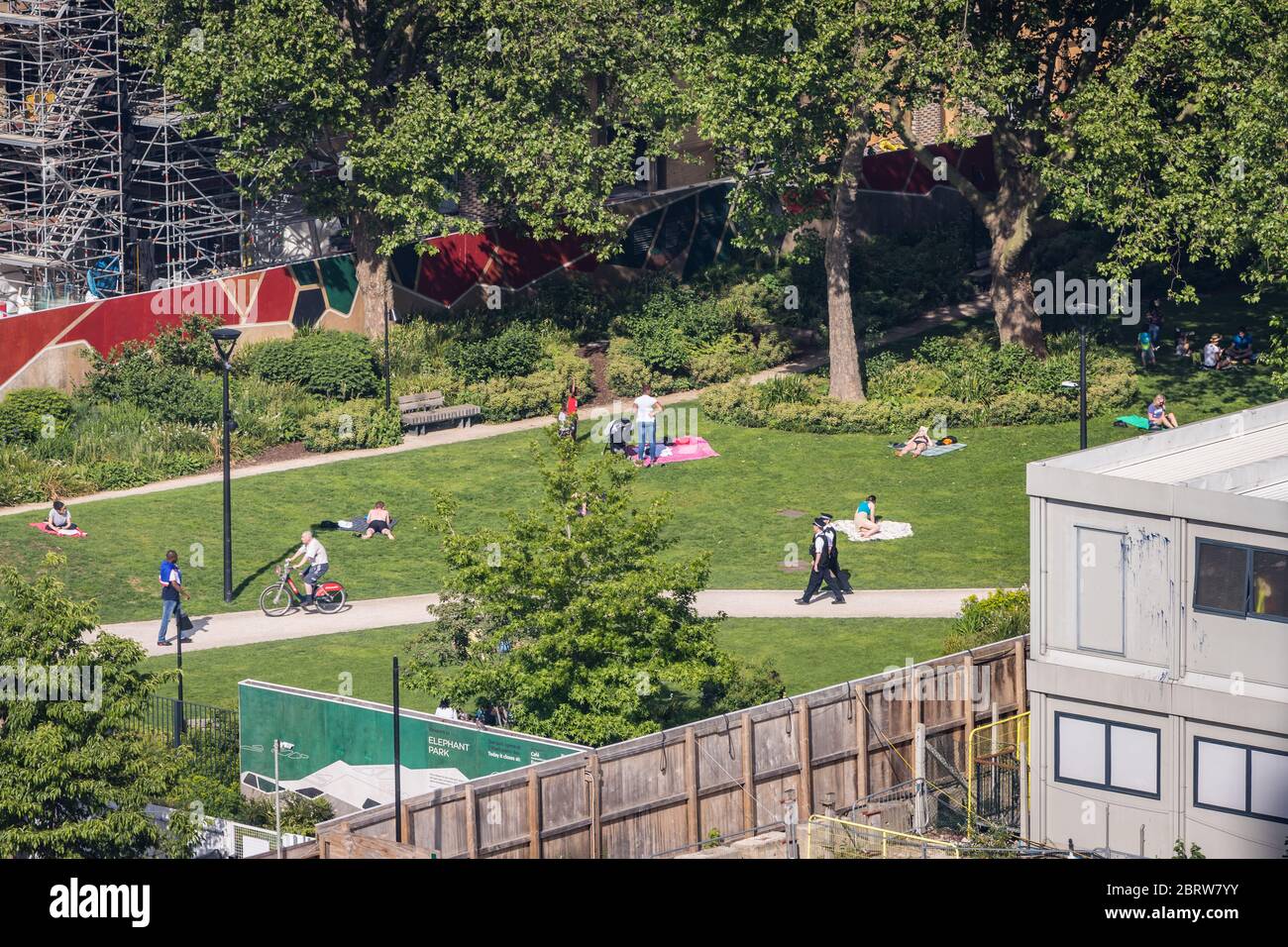 Menschen beobachten soziale Distanz in einem sonnigen Park Stockfoto