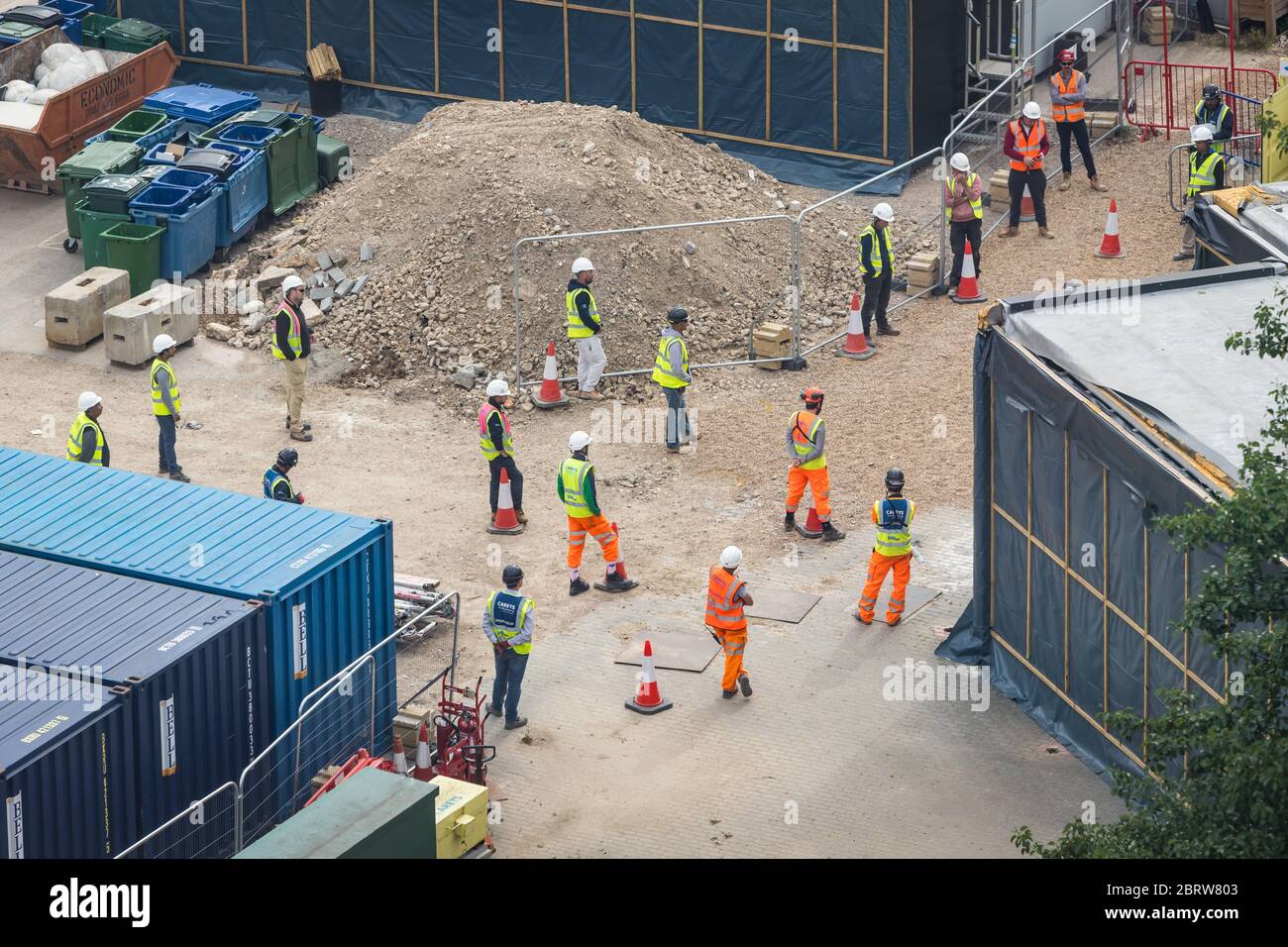 Bauarbeiter beobachten soziale Distanz während eines Teamtreffens Stockfoto