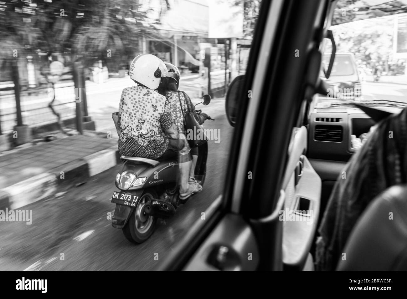 BALI, INDONESIEN - 30. November 2019: Balinesen mit riesigem Gepäck auf dem Roller. Verkehr auf Bali. Indonesien Stockfoto