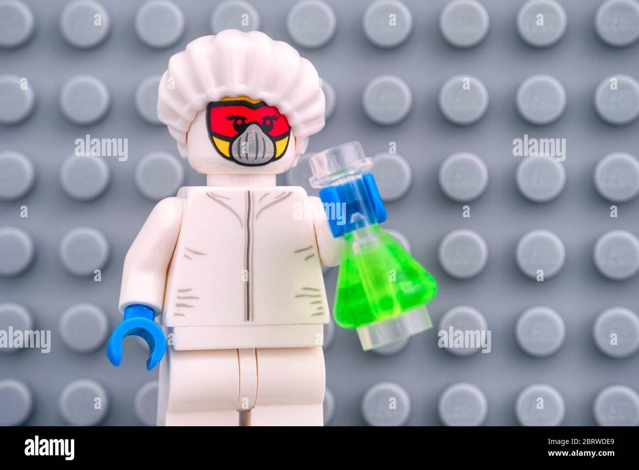 Tambow, Russland - 30. April 2020 Lego Minifiguren Schutzanzug mit grüner Flasche gegen graue Grundplatte. Studioaufnahme. Stockfoto