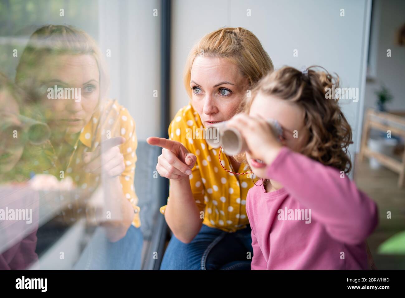 Ein nettes kleines Mädchen mit Mutter drinnen zu Hause, spielen. Stockfoto