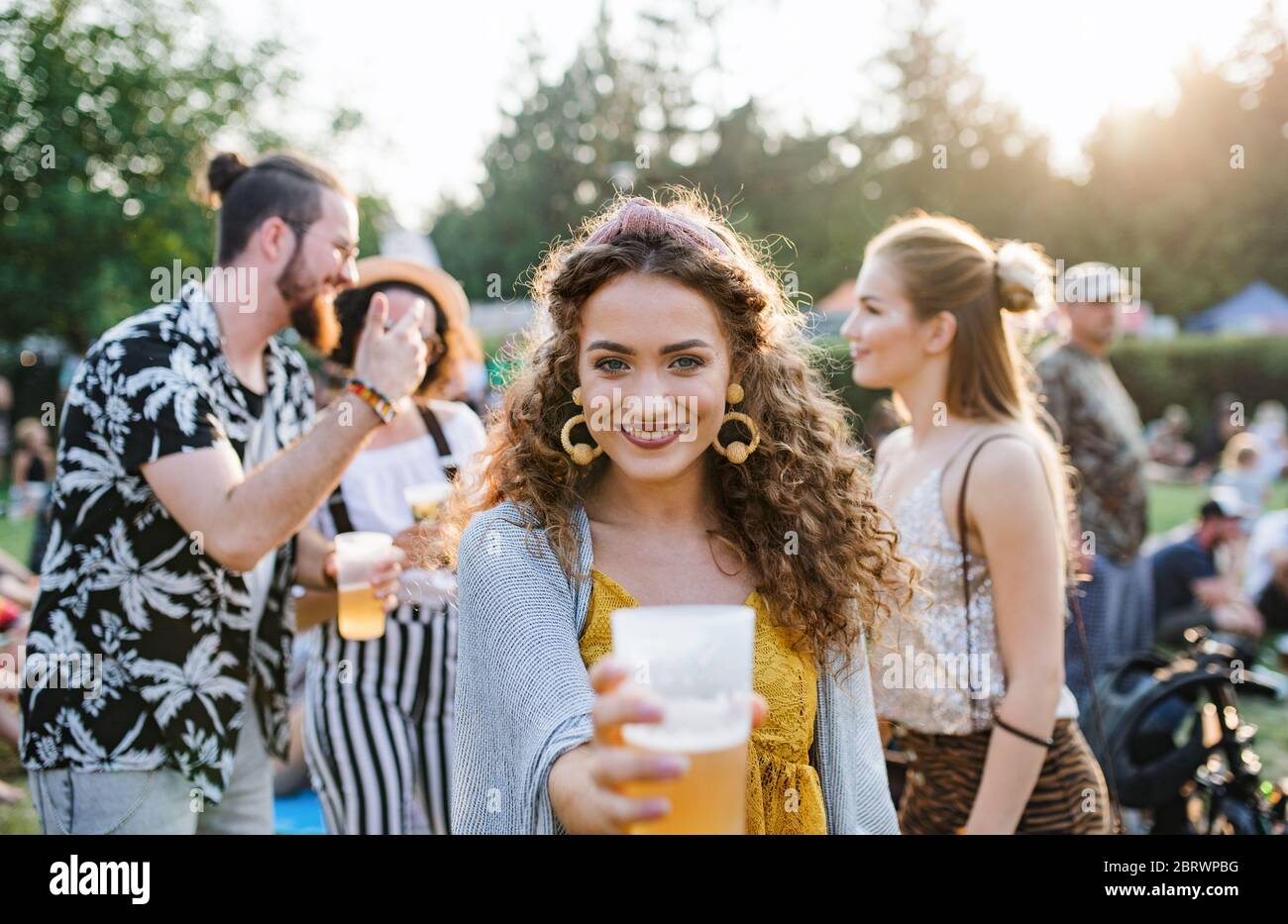 Gruppe von jungen Freunden mit Getränken beim Sommerfest, stehend. Stockfoto