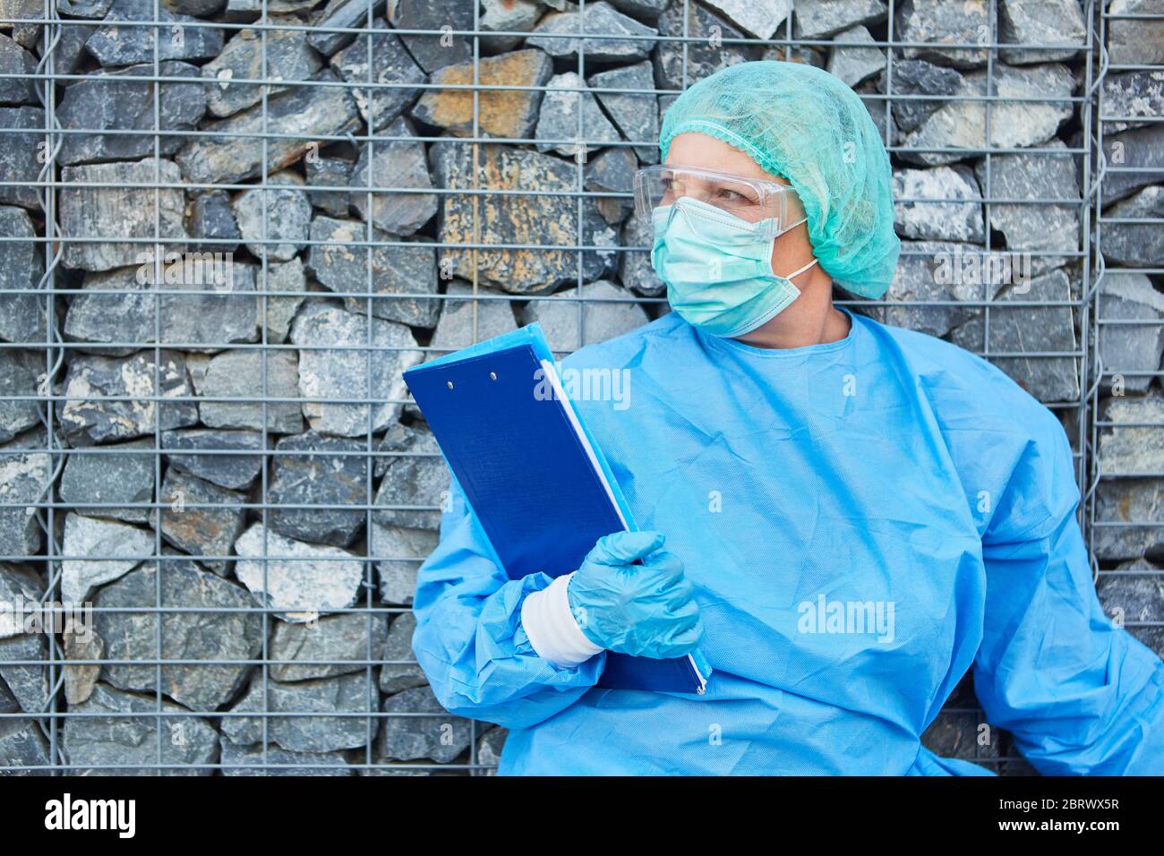 Klinikpersonal oder Eindämmungskläger wartet auf Besucher mit Kontaktauflistenliste für die Coronavirus-Pandemie Stockfoto