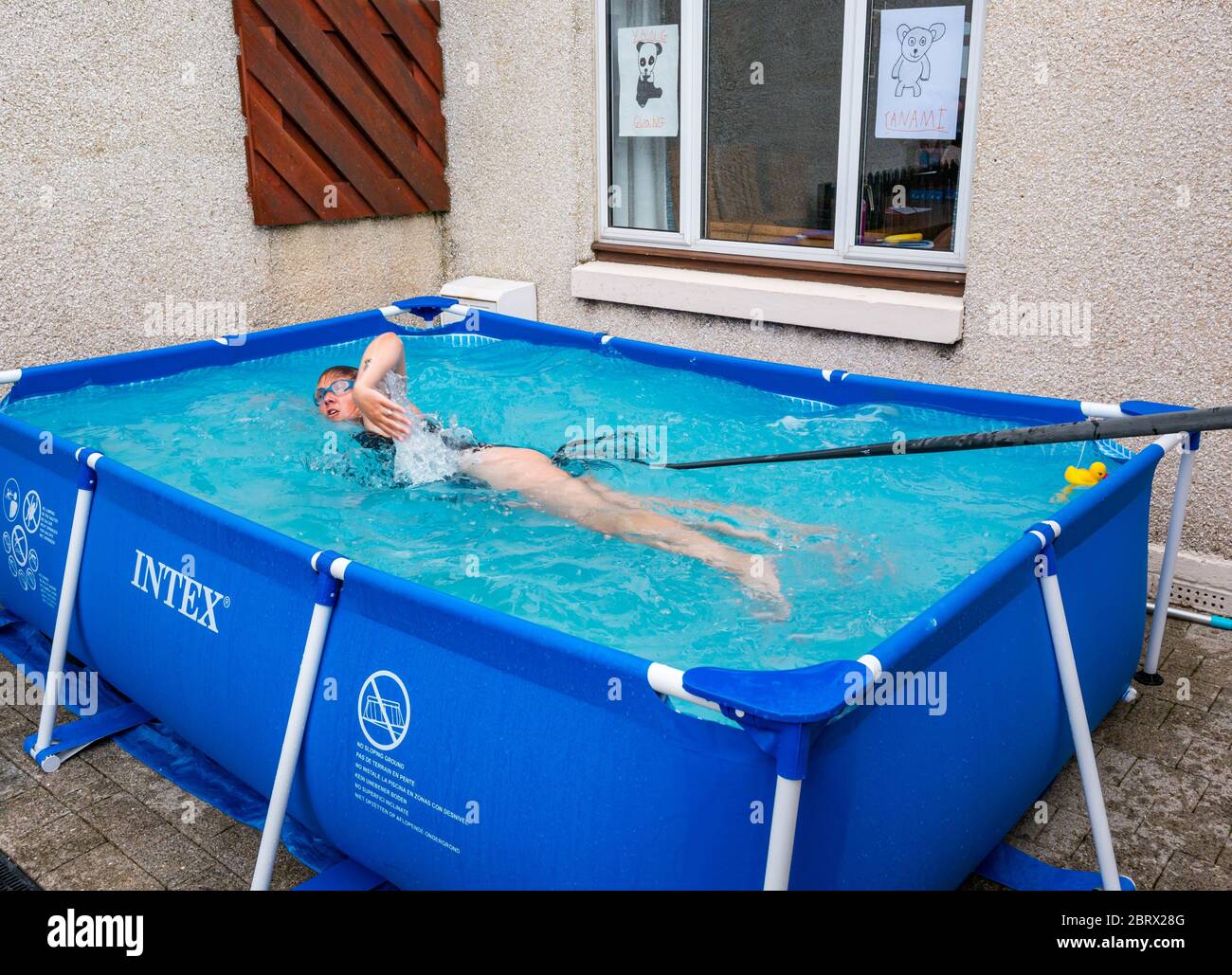 North Berwick, East Lothian, Schottland, Großbritannien, 22. Mai 2020. Aufwertschende Schwimmen im Planschbecken: Jane McMenemy, 40 Jahre, schwimmt 5 Meilen in ihrem Vorgarten, der von einer Widerstandsband gehalten wird, um Geld zu sammeln, um Tiere im Zoo von Edinburgh zu füttern, indem sie während der Covid-19-Sperre einfach nur geben. Ihr Ziel von £500 wurde erreicht, bevor das Schwimmen heute Morgen begann. Die Pools sind 10 Meter lang und 75 cm tief. Bei 1 Meile pro halbe Stunde, sollte es 2.5 Stunden dauern, bis das Ziel erreicht ist Stockfoto