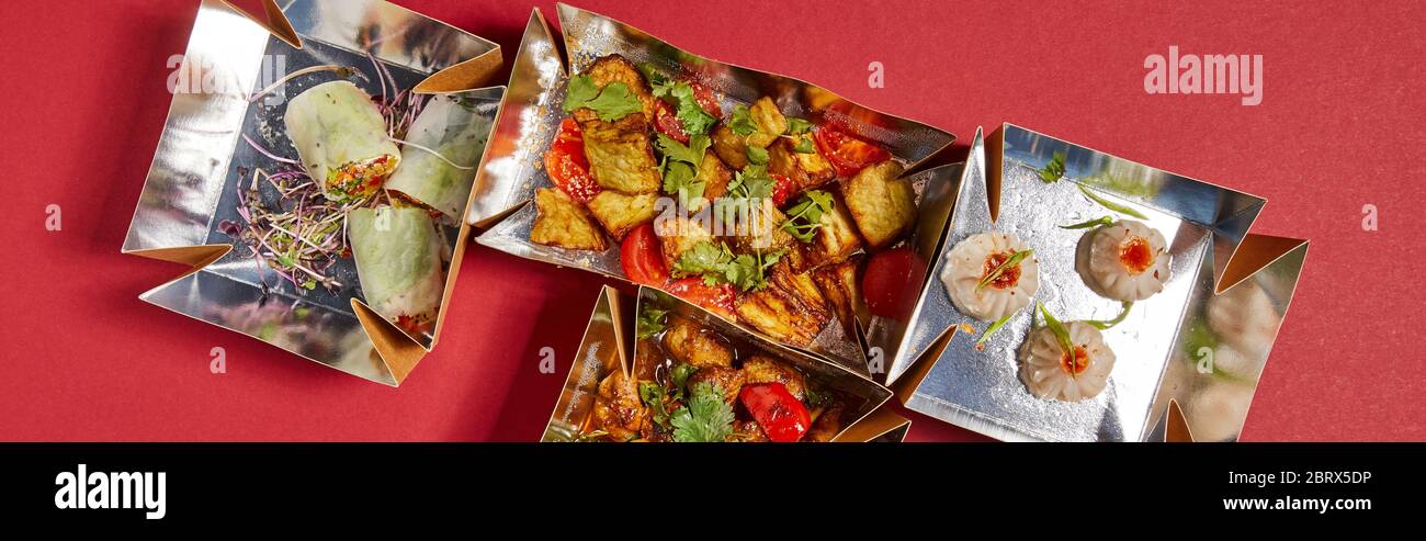 Panorama-Ernte von köstlichen chinesischen Speisen in Take Away Boxen auf rot Stockfoto