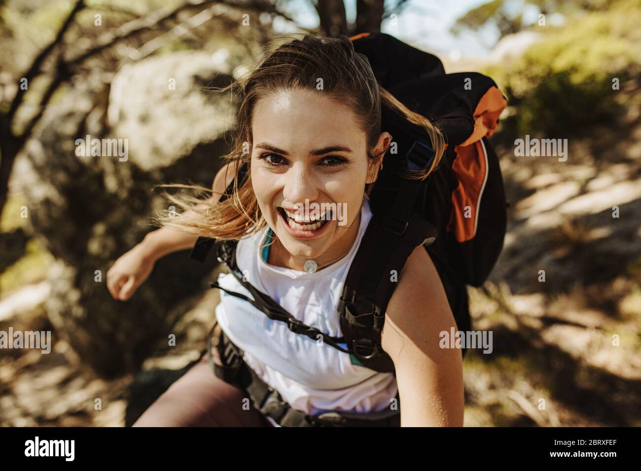 Schöne Frau Wandern Berg. Bergsteigerinnen, die Spaß haben, während sie mit einem Rucksack einen Berg besteigen. Stockfoto