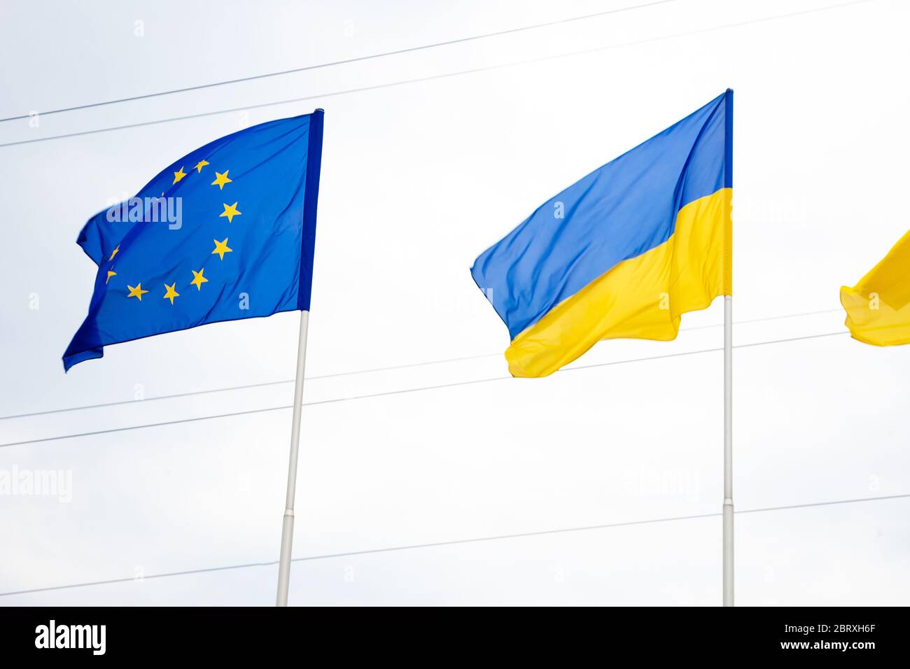 Die Flagge der Europäischen Union und der Ukraine flattert auf dem Fahnenmast. Flaggen Europas. Stockfoto