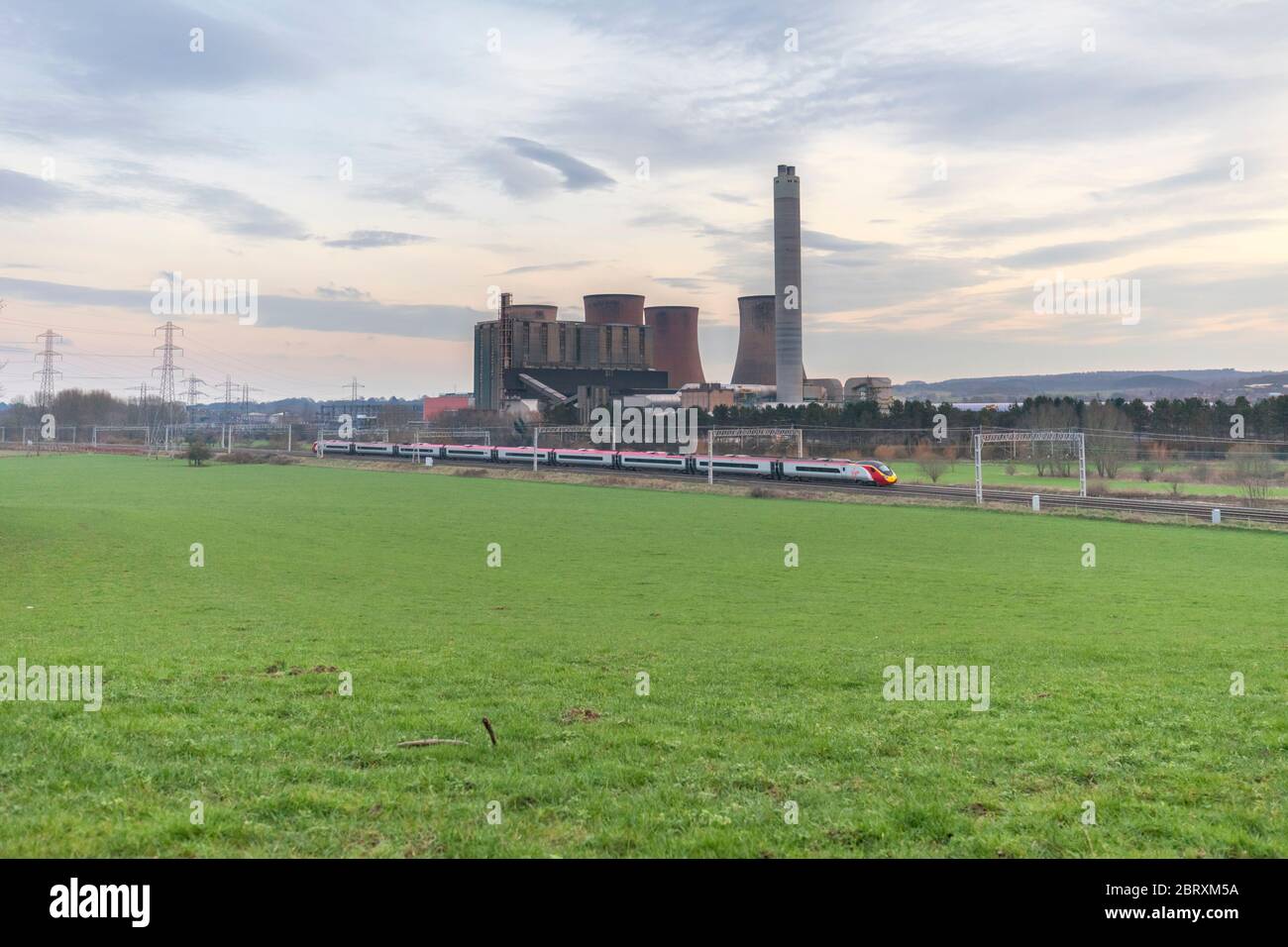 Eine Jungfrau Züge Westküste Pendolino passiert Rugeley Kraftwerk auf der Westküste Hauptlinie. Stockfoto