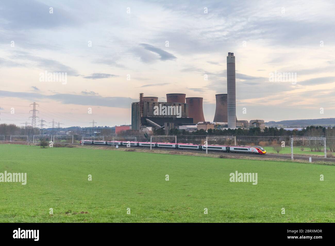 Eine Jungfrau Züge Westküste Pendolino passiert Rugeley Kraftwerk auf der Westküste Hauptlinie. Stockfoto