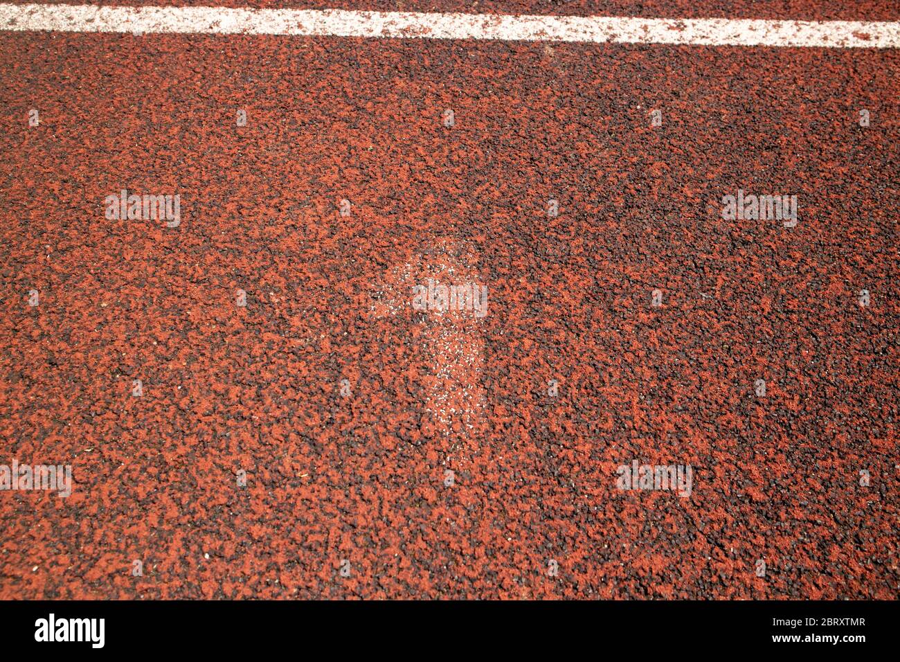 Fast nicht sichtbar weiße Nummer eins, auf der roten Tartan-Laufstrecke gemalt, auf dem Outdoor-Sportplatz in Samobor Stockfoto