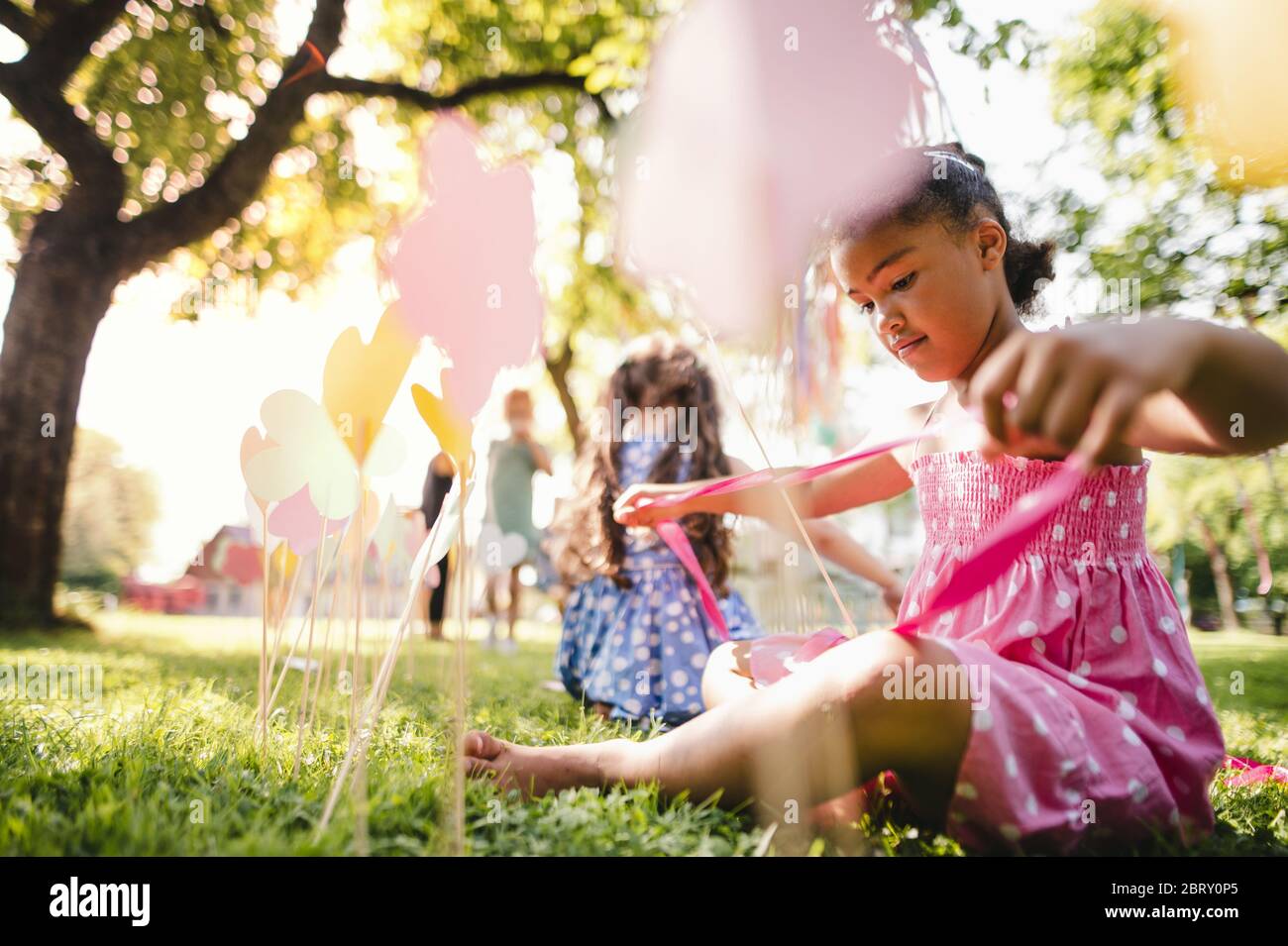 Kleine Kinder im Freien im Garten im Sommer, spielen. Stockfoto