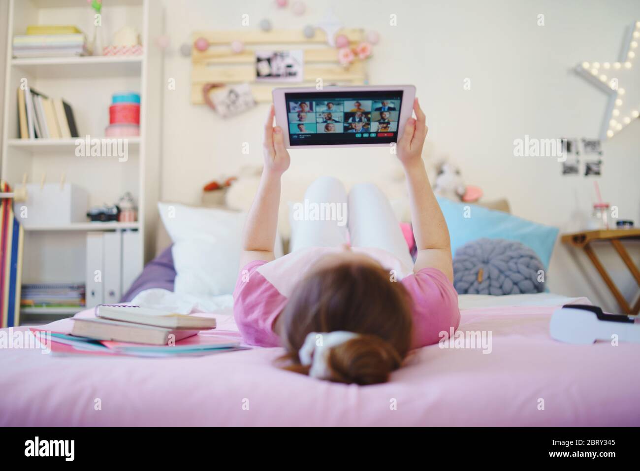 Junges Mädchen mit Tablet auf dem Bett, während der Quarantäne entspannen. Kopierbereich. Stockfoto