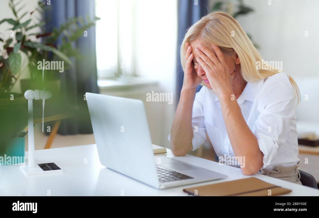 Frustrierte Frau Ingenieur mit Laptop im Home Office, arbeitet. Stockfoto