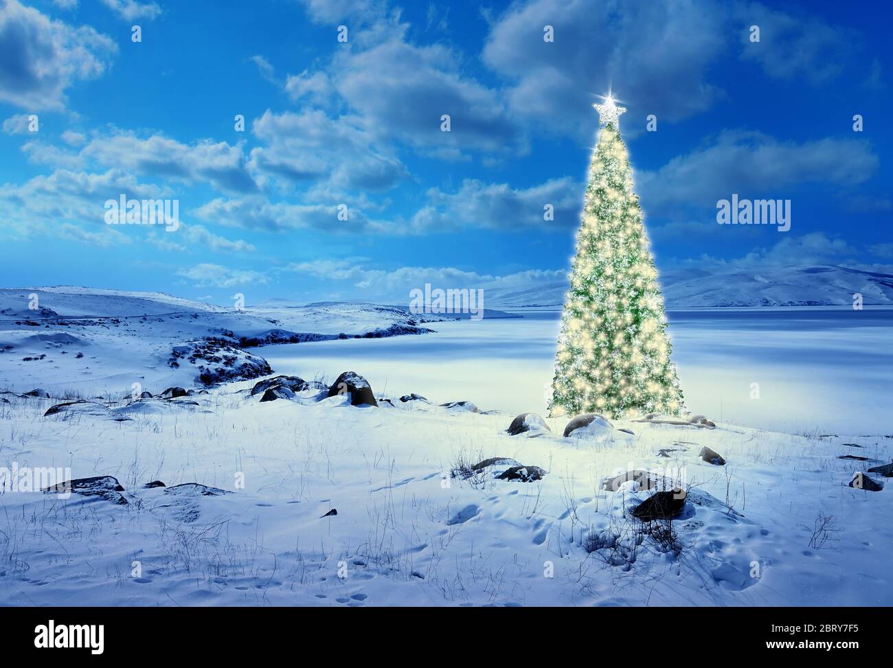 Konzeptionelle Bild der geschmückten Weihnachtsbaum mit bunten Lichtern und Ornamente auf schneebedeckten Landschaft Stockfoto