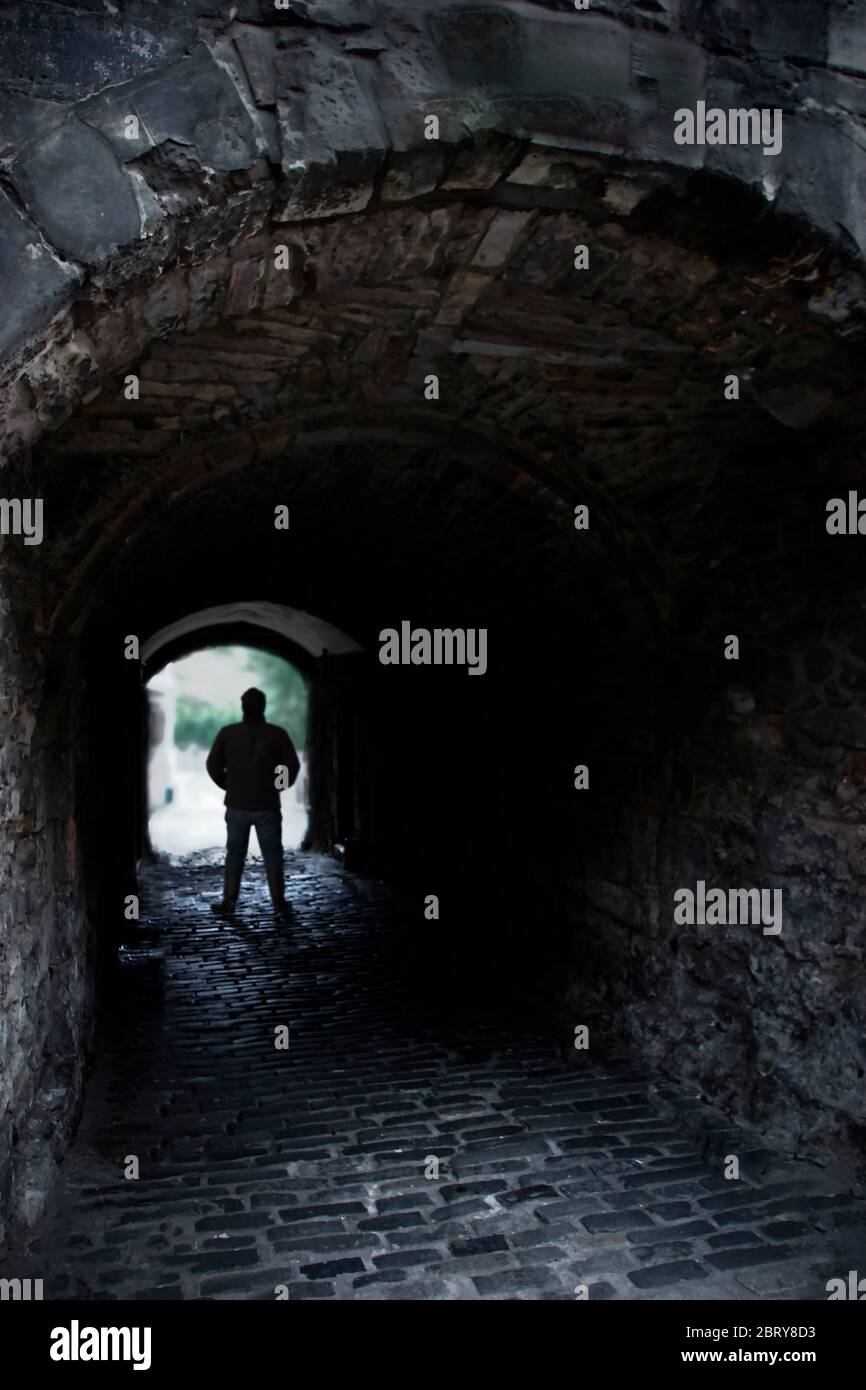 Mann, der in einem alten Backsteintunnel steht Stockfoto