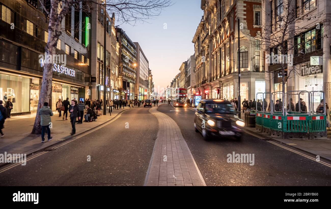 Oxford Street, London. Shopper und Verkehr in der Nacht im Einkaufs- und Einkaufsviertel der britischen Hauptstadt. Stockfoto