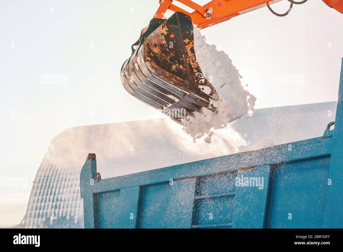 Schneeräumung nach Schneefall und Schneesturm. Bagger lädt Schnee in einen LKW Stockfoto