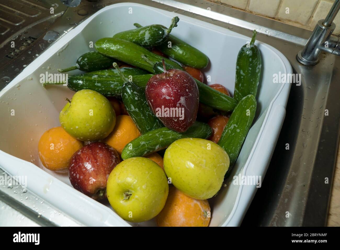 Seifige frische Äpfel Gurken und Orangen in der Küche Stockfoto