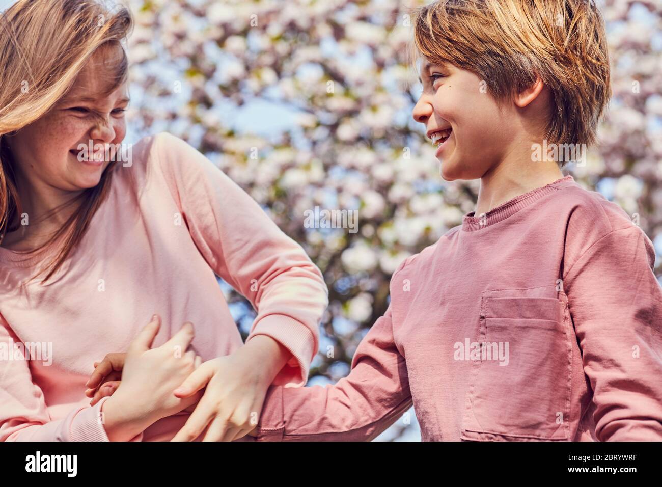 Lächelnd brünette junge und Mädchen im Freien stehen, neckend einander. Stockfoto
