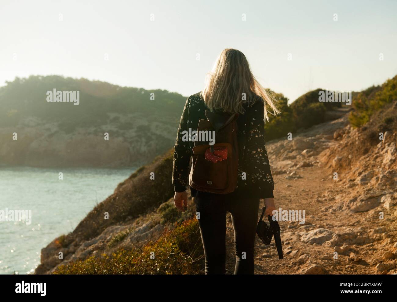 Rückansicht der Frau, die an der Küste von Katalonien zwischen Sitges und Vilanova i la Geldru, Spanien, wandert. Stockfoto