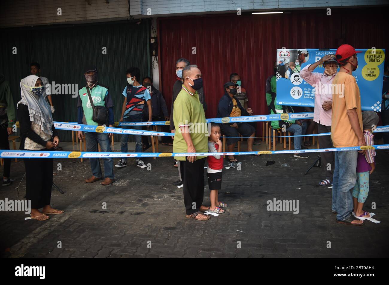 Jakarta, Indonesien. Mai 2020. Indonesische Muslime stehen mit sozialer Distanz an, um während der Coronavirus-Pandemie im heiligen Monat Ramadan in Jakarta, Indonesien, 22. Mai 2020, kostenlose Nahrung für Iftar oder eine schnelle Mahlzeit zu erhalten. Kredit: Zulkarnain/Xinhua/Alamy Live News Stockfoto