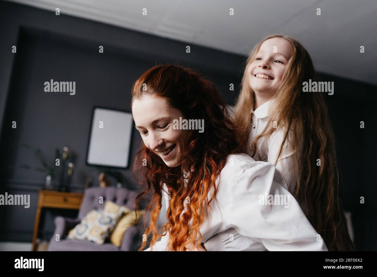 Zwei Schwestern umarmen sich im Loft, die Freundschaft, Vertrauen, Ähnlichkeit darstellen Stockfoto