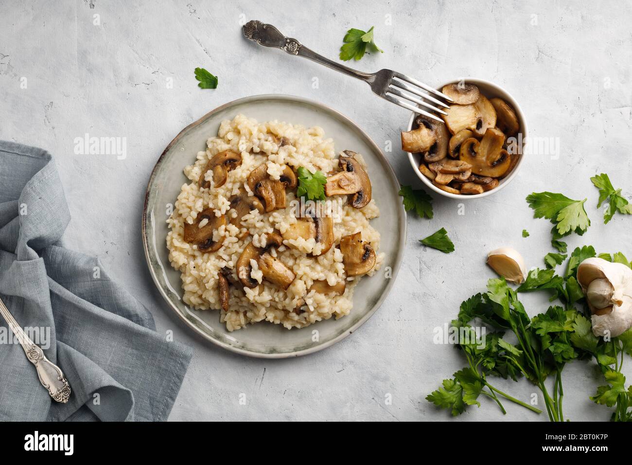 Ein Gericht der italienischen Küche - Risotto aus Reis und Pilzen. Draufsicht. Flaches Lay. Heller Hintergrund. Stockfoto