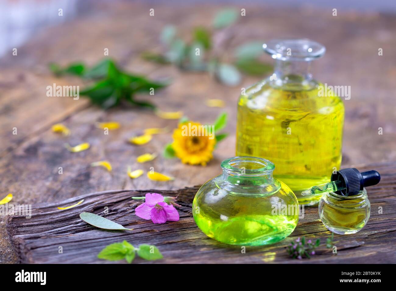 Alternative Medizin mit ätherischen Ölen, Flasche trank und Blumen auf einem Holztisch. Stockfoto
