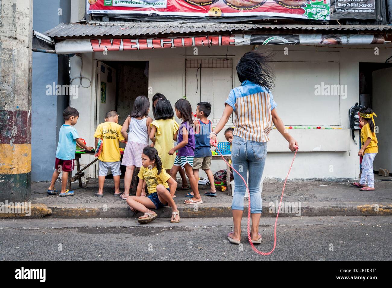 Junge philippinische Kinder spielen auf der Straße in der alten ummauerten Stadt Intramuros, Manila, Philippinen. Stockfoto