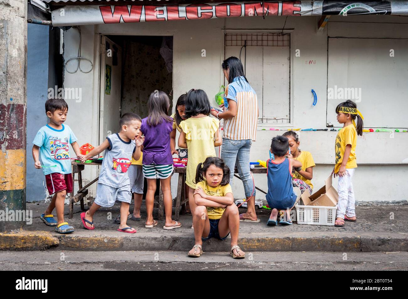 Junge philippinische Kinder spielen auf der Straße in der alten ummauerten Stadt Intramuros, Manila, Philippinen. Stockfoto